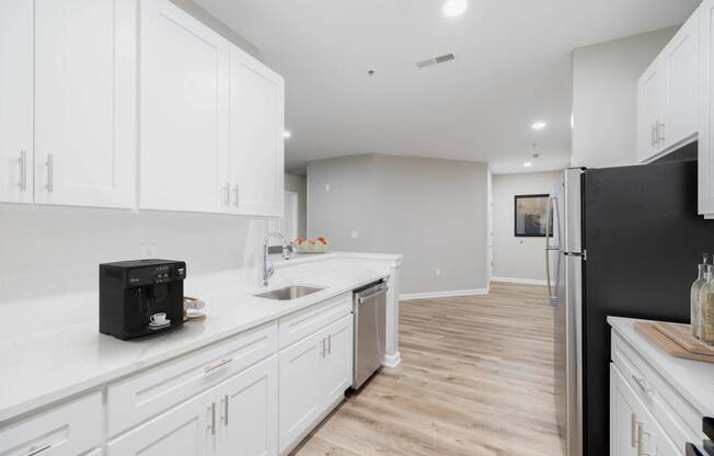 a white kitchen with white cabinets and a black refrigerator