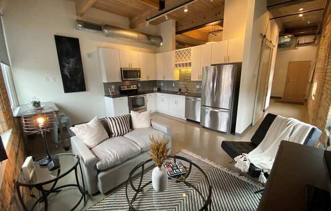 A modern living room with a black and white striped rug and a glass coffee table.