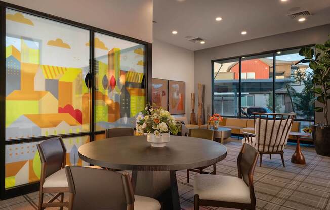 a dining room with tables and chairs and large windows at Weylyn Luxury Apartments, Laveen, 85339