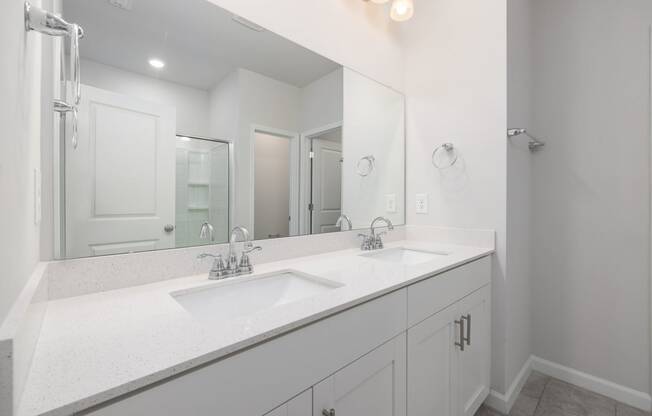 a white bathroom with two sinks and a large mirror