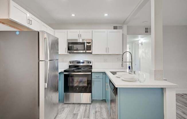 A modern kitchen with a stainless steel refrigerator and a stove top oven.