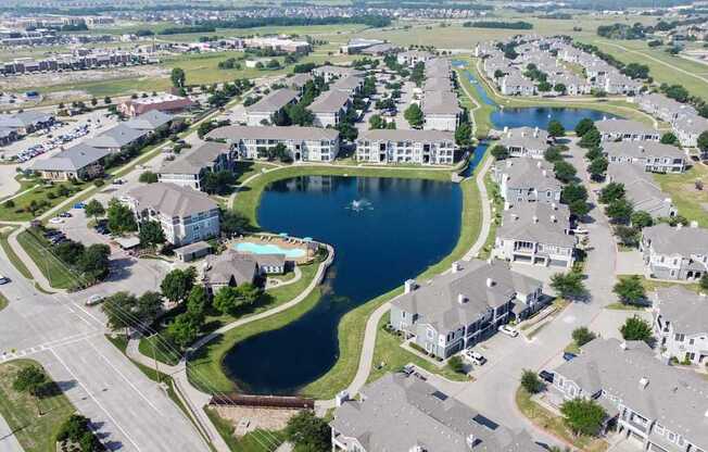 A bird's eye view of a residential area with a large lake in the middle.