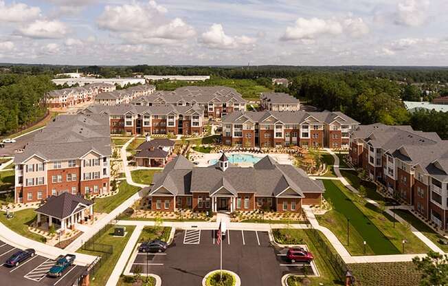 Aerial view of community clubhouse, parking lot and apartment buildings