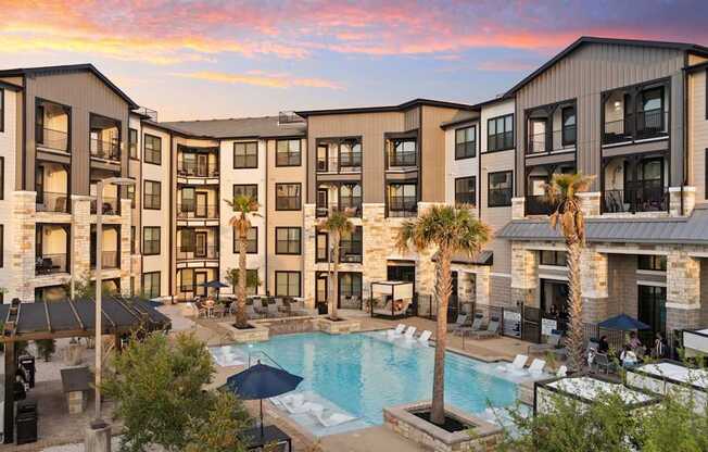 A large apartment complex with a pool in the foreground.
