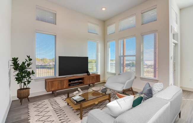 a living room with a white couch and a television