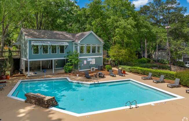 a swimming pool with a house in the background