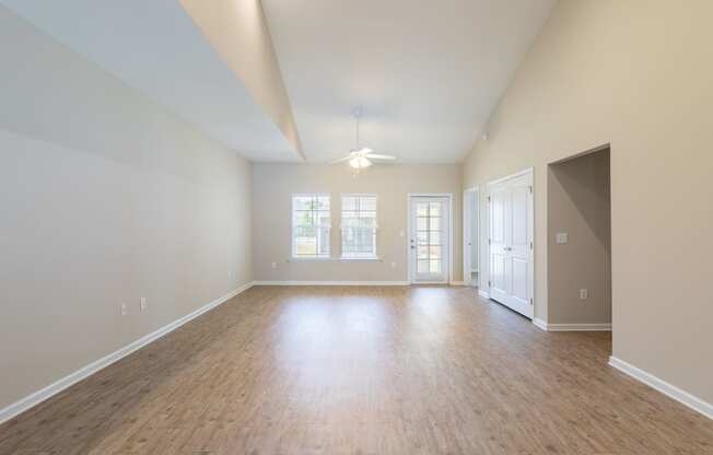 an empty living room with a hard wood floor and white walls