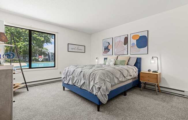 A bedroom with a bed, nightstand, and pictures on the wall.