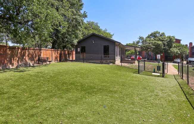 A backyard with a fence and a small building.