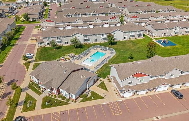 A swimming pool is surrounded by houses in a residential area.