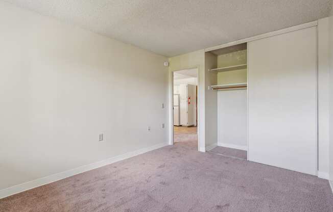 the living room of an apartment with carpet and white walls