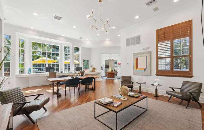 A modern living room with a glass table and black chairs.