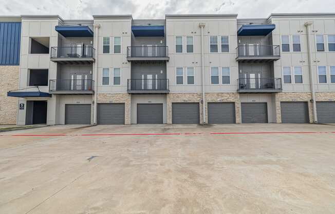 an empty parking lot in front of an apartment building