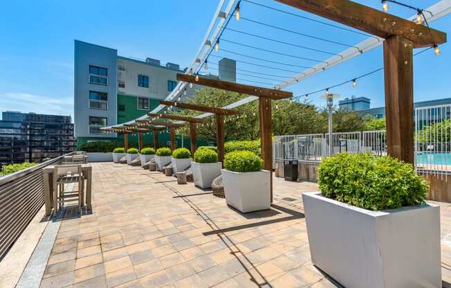 a roof terrace with chairs and potted plants and a pool