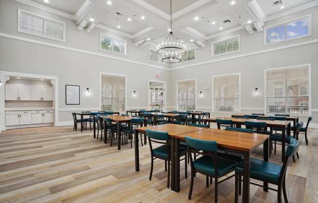 a dining room with tables and chairs and a kitchen