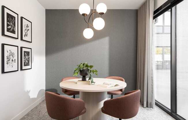 A modern dining room with a round table and chairs.