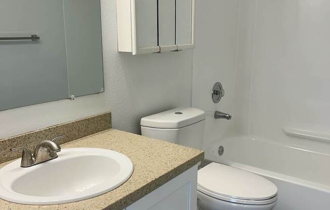 A white toilet sits next to a sink in a bathroom.