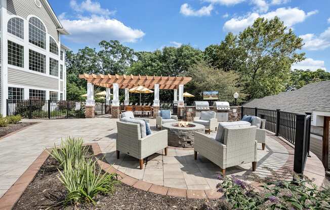 A patio area with a table and chairs is surrounded by a black fence.