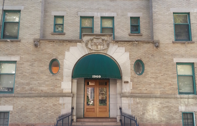 Historic brick apartment facade with green awnings and well-maintained entrance.