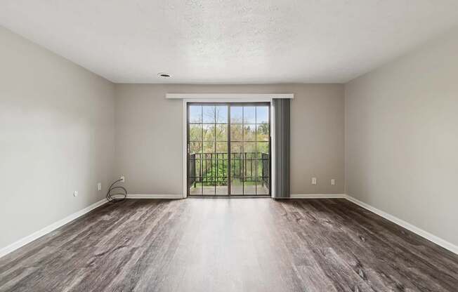 A room with a sliding glass door leading to a balcony.