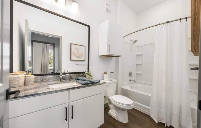 A bathroom with a white toilet, sink, and bathtub.