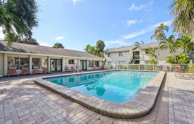 A swimming pool surrounded by a brick patio.