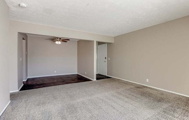 A room with a ceiling fan and carpeted floor. Omaha, NE Evergreen Terrace Apartments