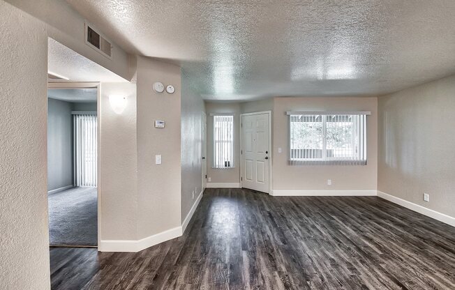 an empty living room with hardwood floors