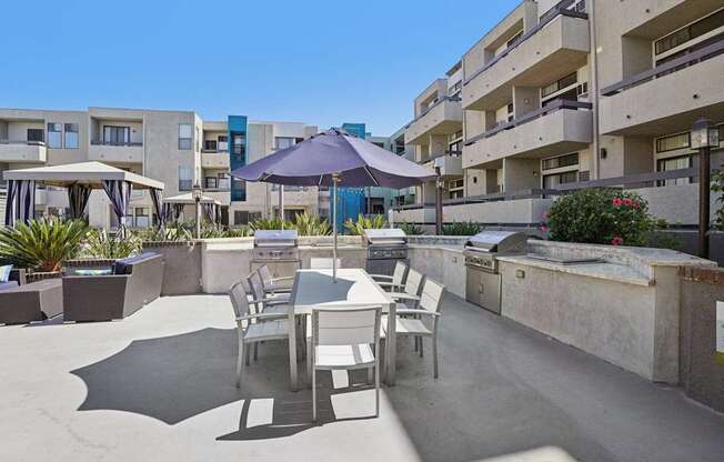 A patio with a table and chairs is surrounded by buildings.