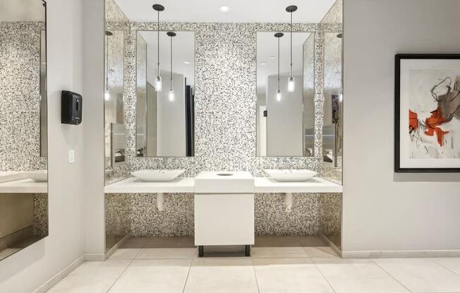 a bathroom with two sinks and three mirrors