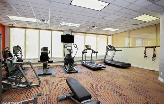 a room filled with exercise equipment and a flat screen tv