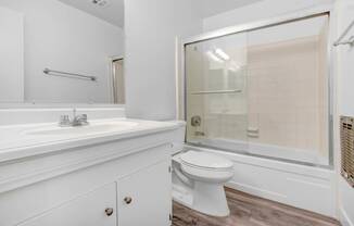a bathroom with a toilet and a sink and a shower