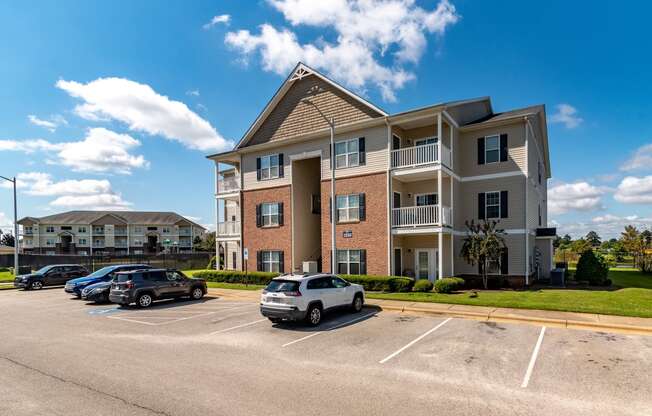 a large apartment building with cars parked in a parking lot