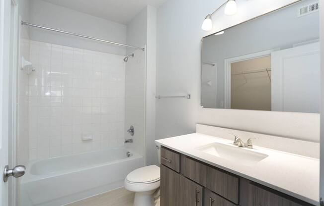A white bathroom with a toilet, sink, and shower.