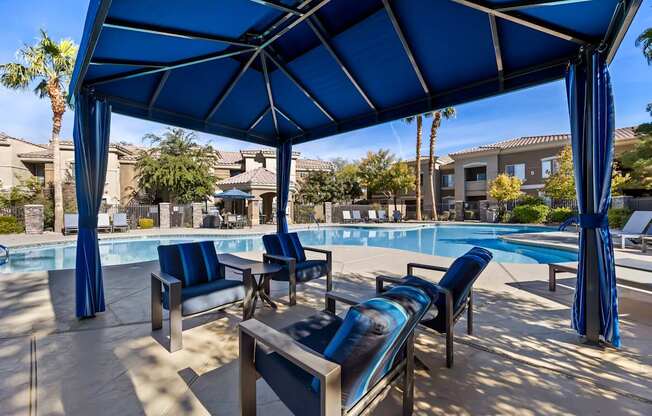 A poolside area with blue umbrellas and lounge chairs.