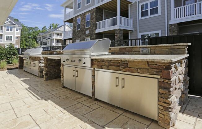 an outdoor kitchen with stainless steel appliances and a stone facade