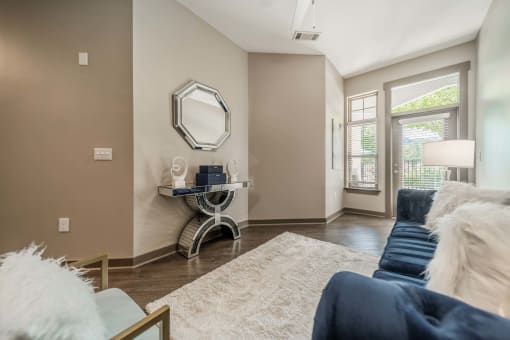 a living room with a couch and a table with a mirror