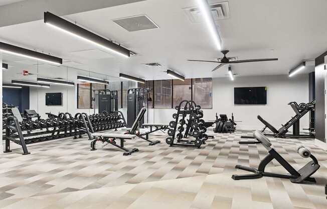 A spacious gym with a variety of equipment and a checkered floor. at Brickside Heights, Utah, 84106
