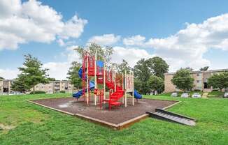 A playground with a red slide and a blue slide.
