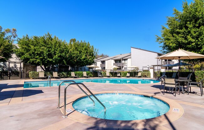 A swimming pool surrounded by trees and chairs.