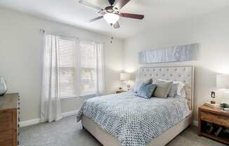 a bedroom with a bed and a ceiling fan