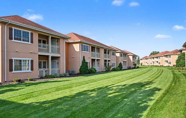 Exterior building with sprawling green lawn at The Residences at Toscana Park in Granger, Indiana.