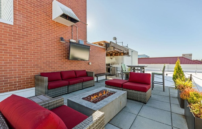 A patio with a fire pit and seating area.