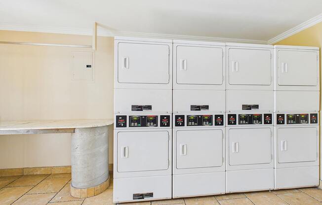A row of white refrigerators are lined up in a room.