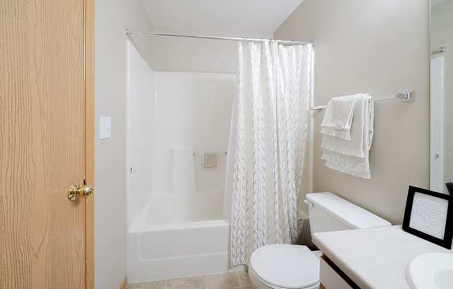 a bathroom with a shower tub combo and a toilet and a sink
