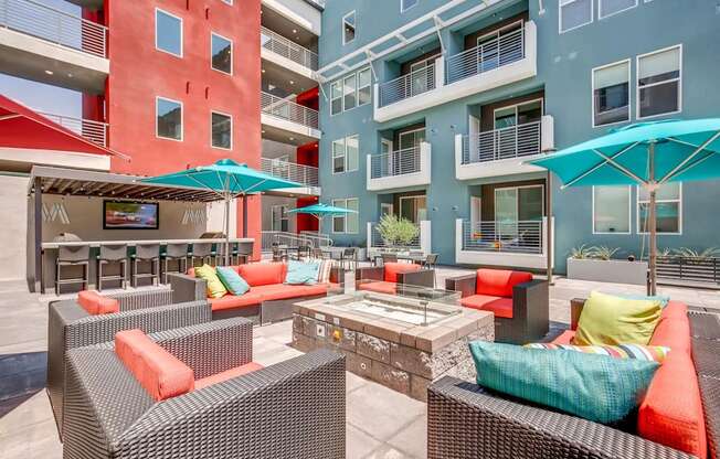 A patio with a table and chairs and umbrellas.