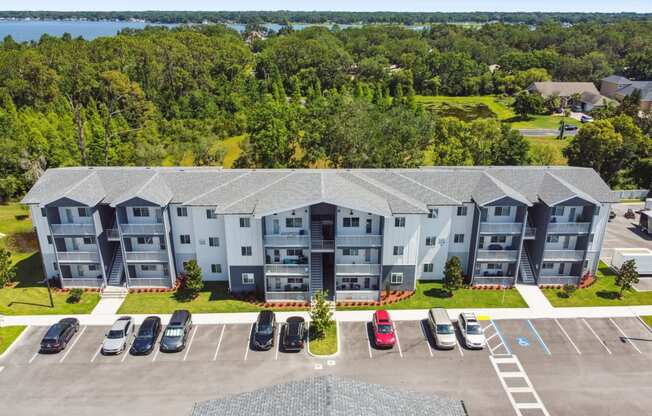 an aerial view of an apartment building and parking lot with cars at Gibson Oaks, Lakeland, 33809