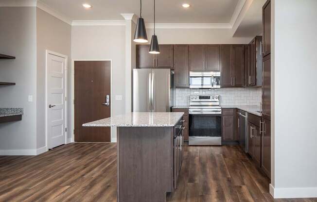 A modern kitchen with a wooden floor and stainless steel appliances.