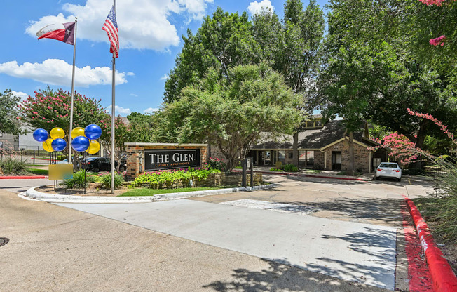 The entrance to The Glen with a flag and balloons.