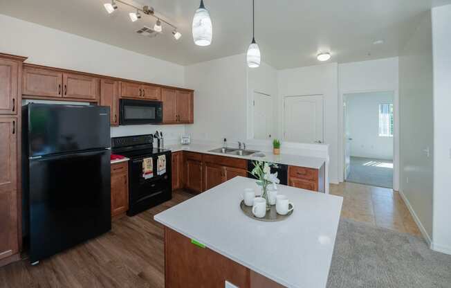 a kitchen with a white counter top and a black refrigerator